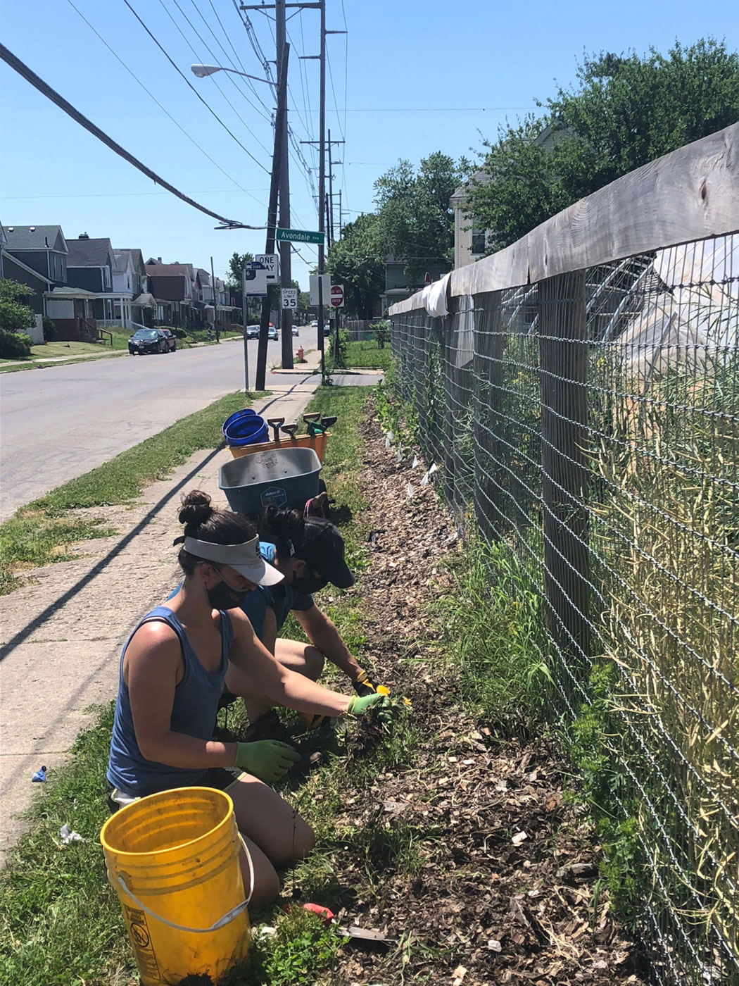 Volunteers clean up along a fence at Franklinton Farms. Photo by Edible Columbus.