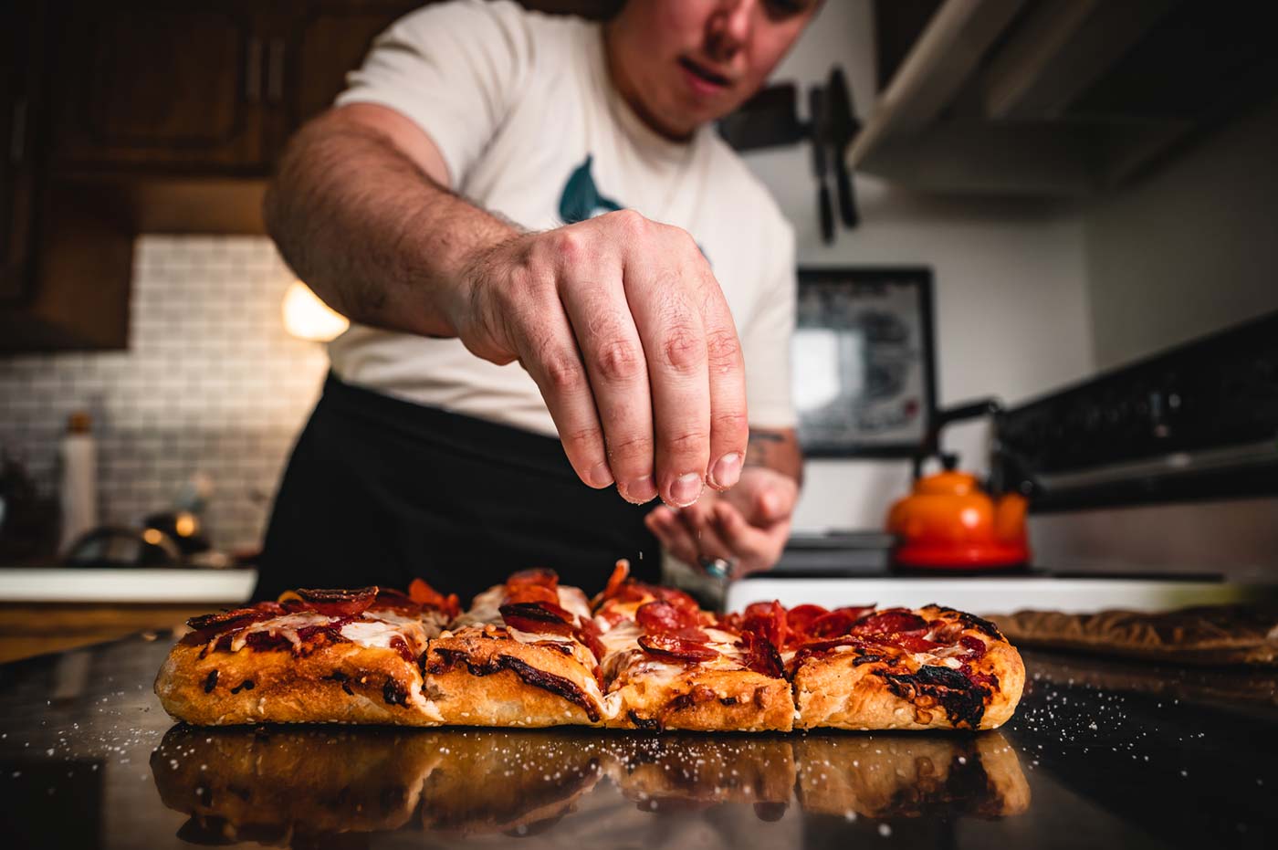 The Wizard of Za adds final touches to one of his signature hand-made pizzas.
