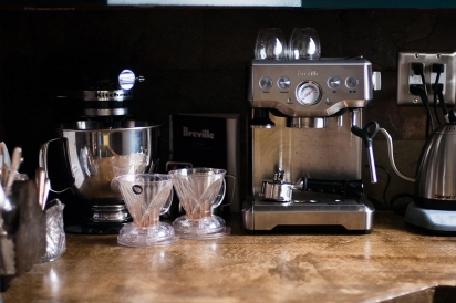 An assortment of coffee brewing tools lines the back counter.