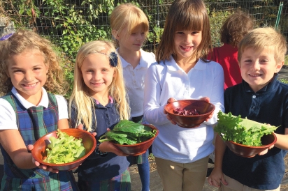 students with fresh harvest of lettuce