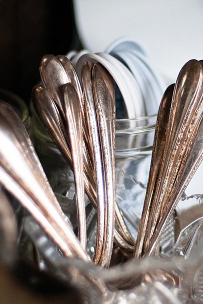 Silverware is displayed in glasses on the countertop.